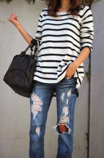 Woman posing in striped shirt and distressed jeans. 